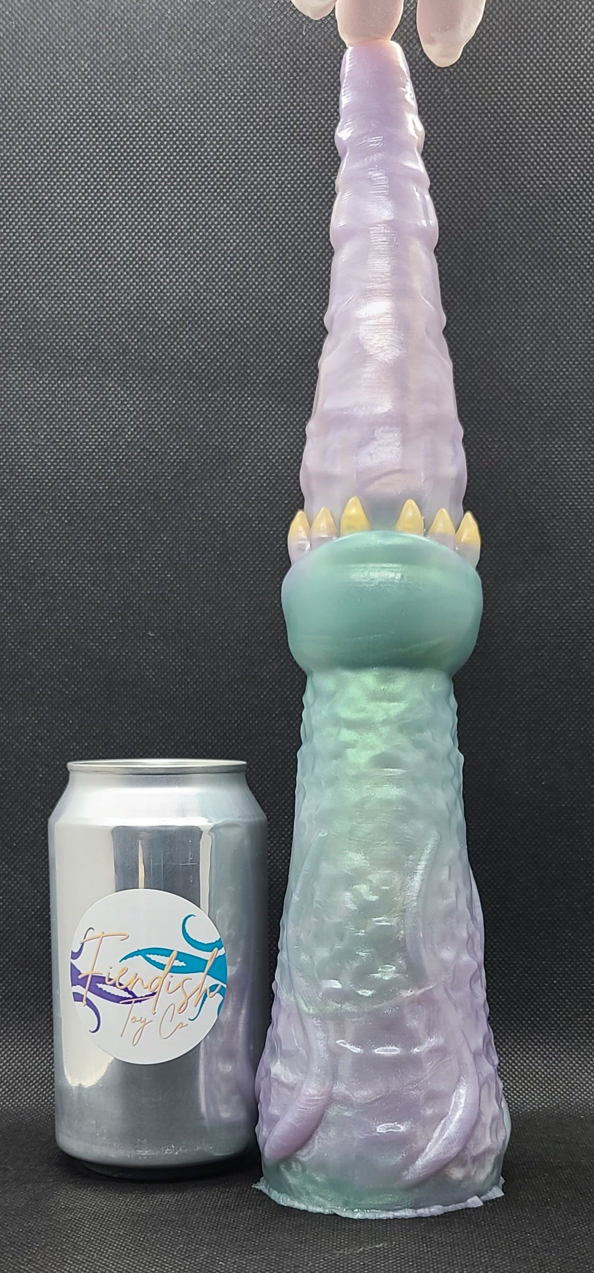 Fantasy-themed product with a can for scale on a dark background